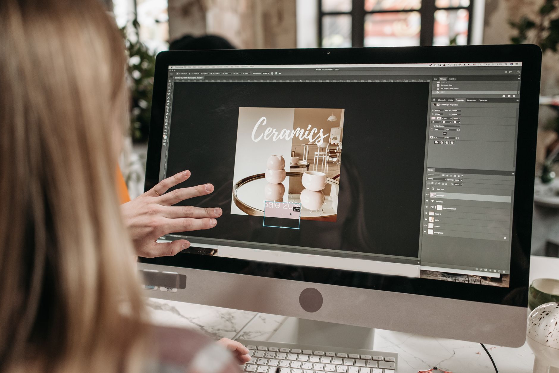 woman using silver imac and apple keyboard